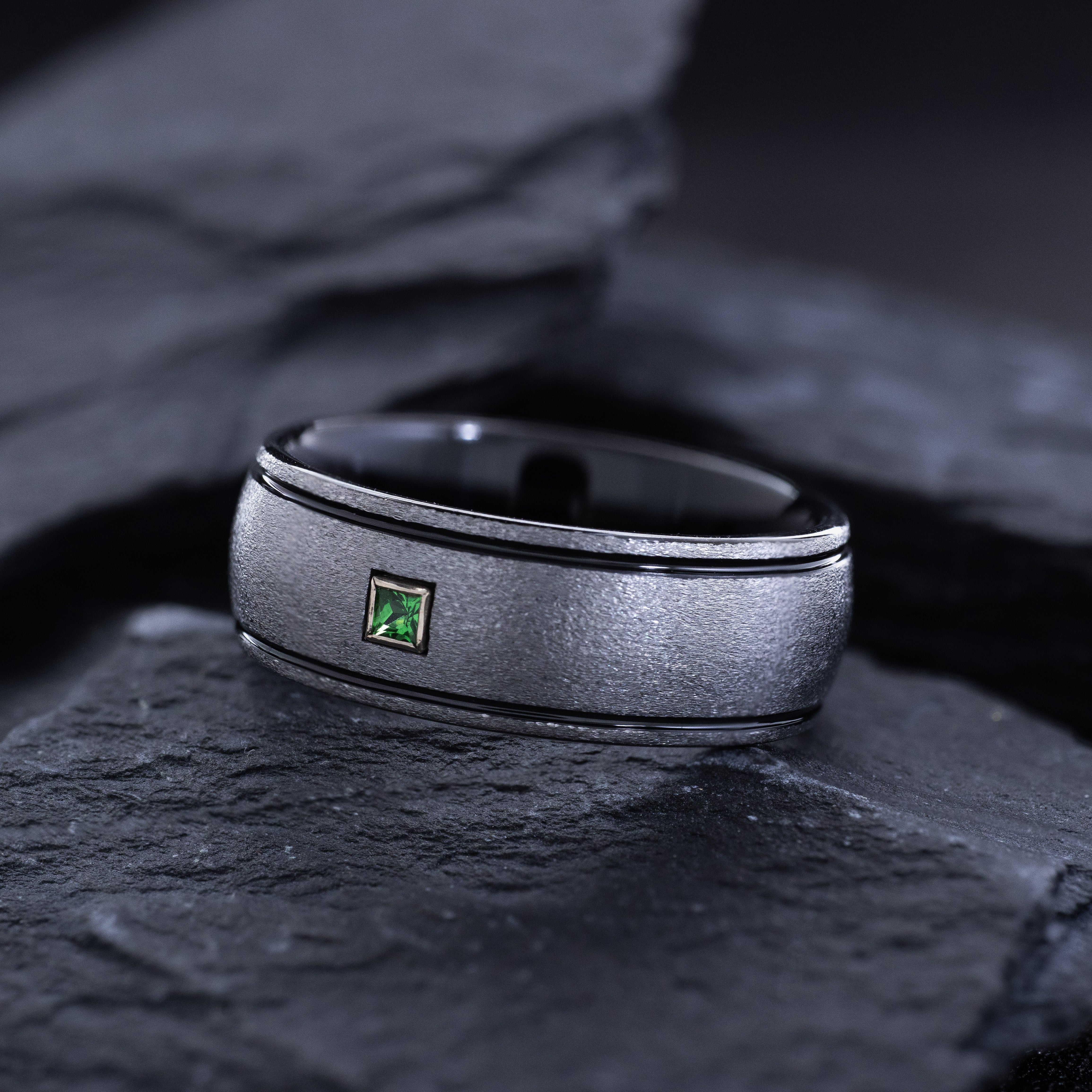 Tungsten Carbide ring with gemstone on stone finish surface